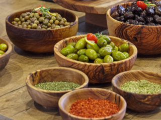 Close-up of a gourmet selection of green and black olives, served with aromatic spices at the Ibis Hotel Tuzla breakfast buffet.
