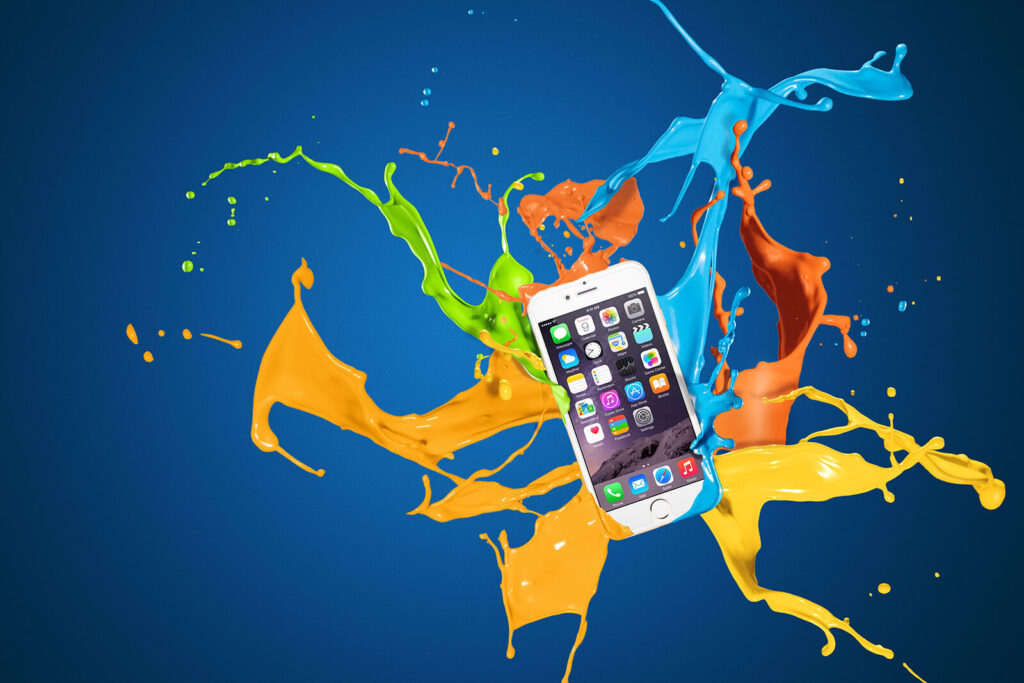 iPhone&rsquo;un renkli boya sı&ccedil;ramaları arasında s&uuml;z&uuml;ld&uuml;ğ&uuml;, teknoloji ve yaratıcılığı g&ouml;rsel olarak &ccedil;arpıcı bir şekilde sunan reklam g&ouml;rseli.